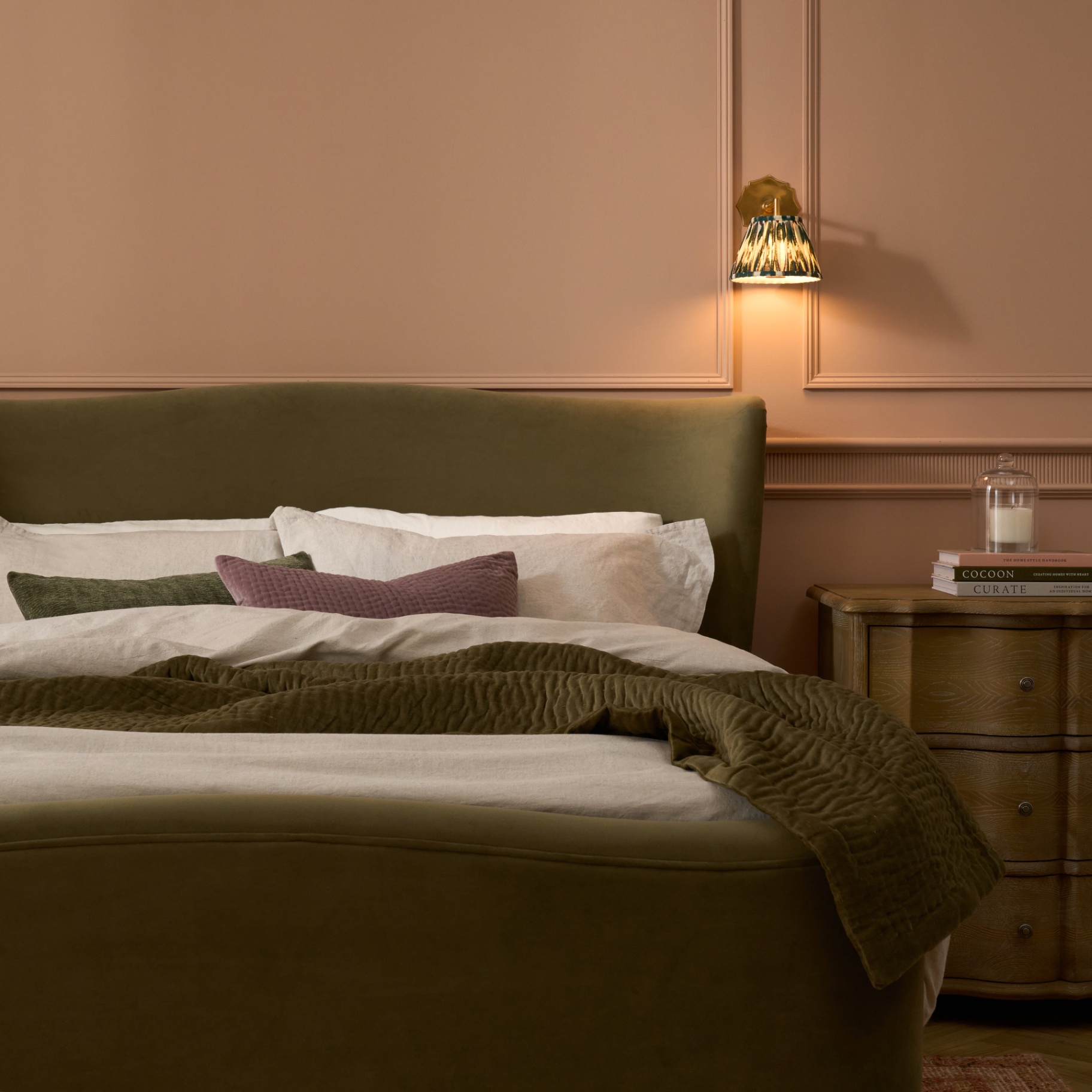 Olive velvet bed in blush panelled bedroom
